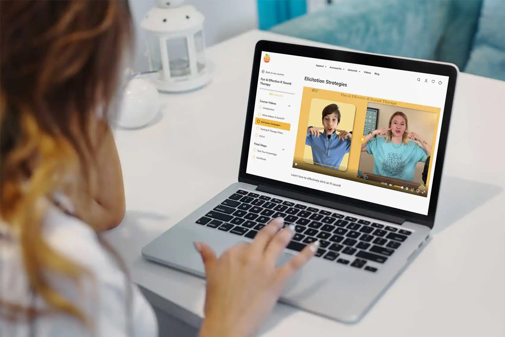 MacBook laptop displaying a video call or virtual meeting on its screen.