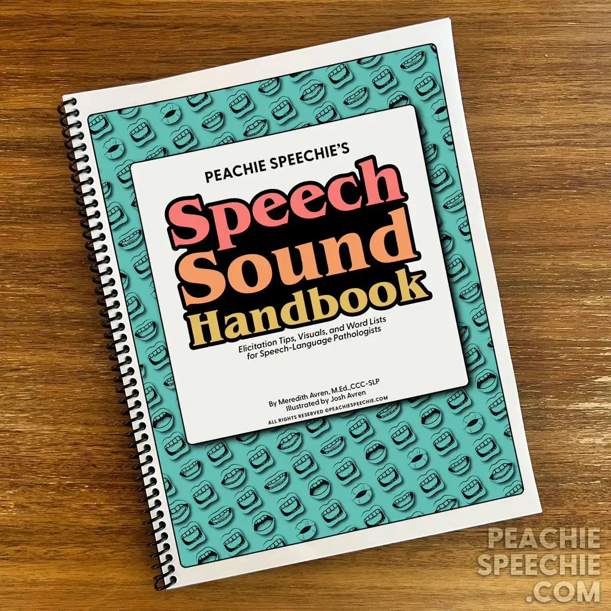 Spiral-bound ’Speech Sound Handbook’ with a teal patterned cover and coral-colored text.
