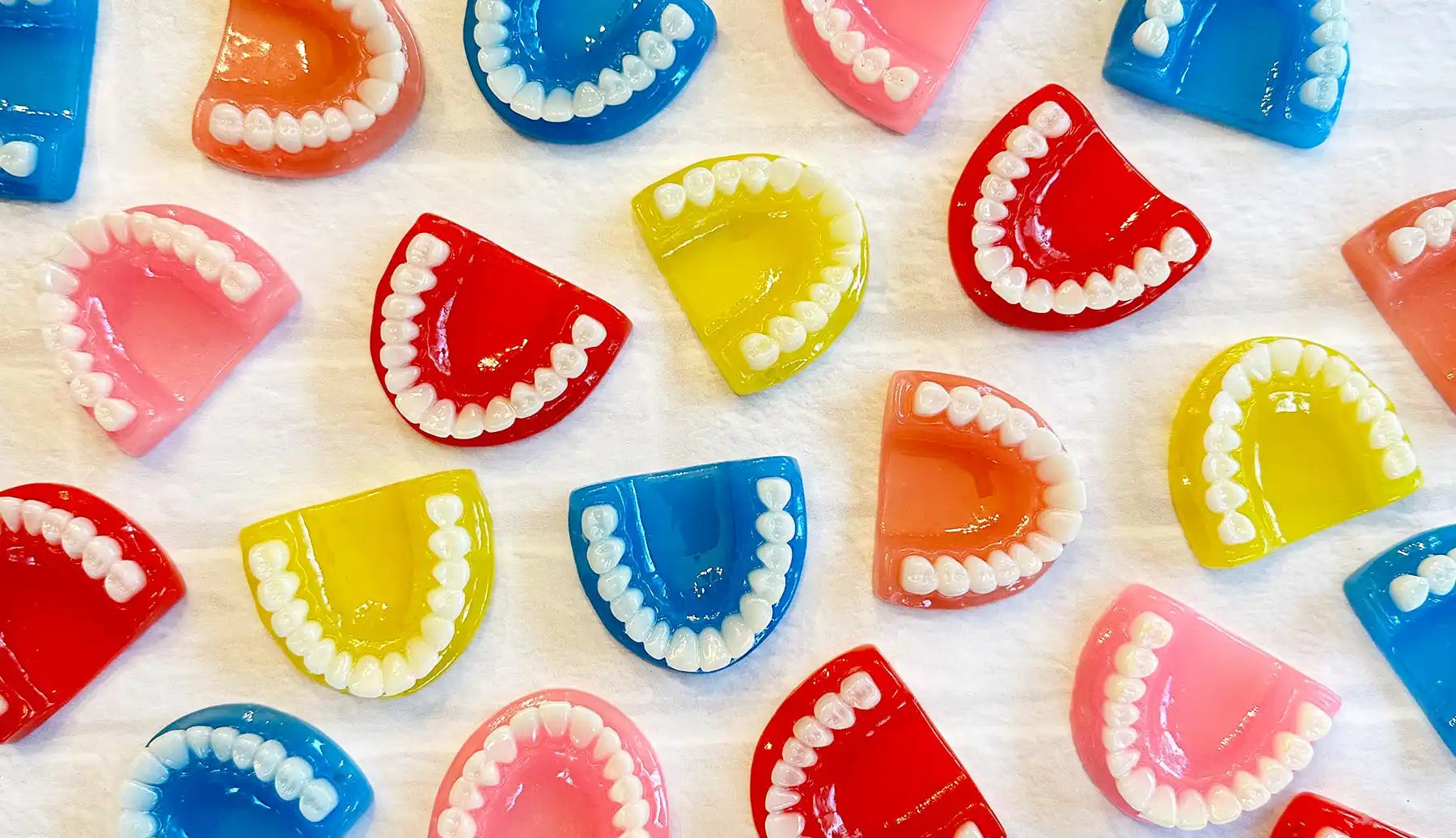 Colorful dental impressions arranged in a pattern showing upper and lower teeth molds.