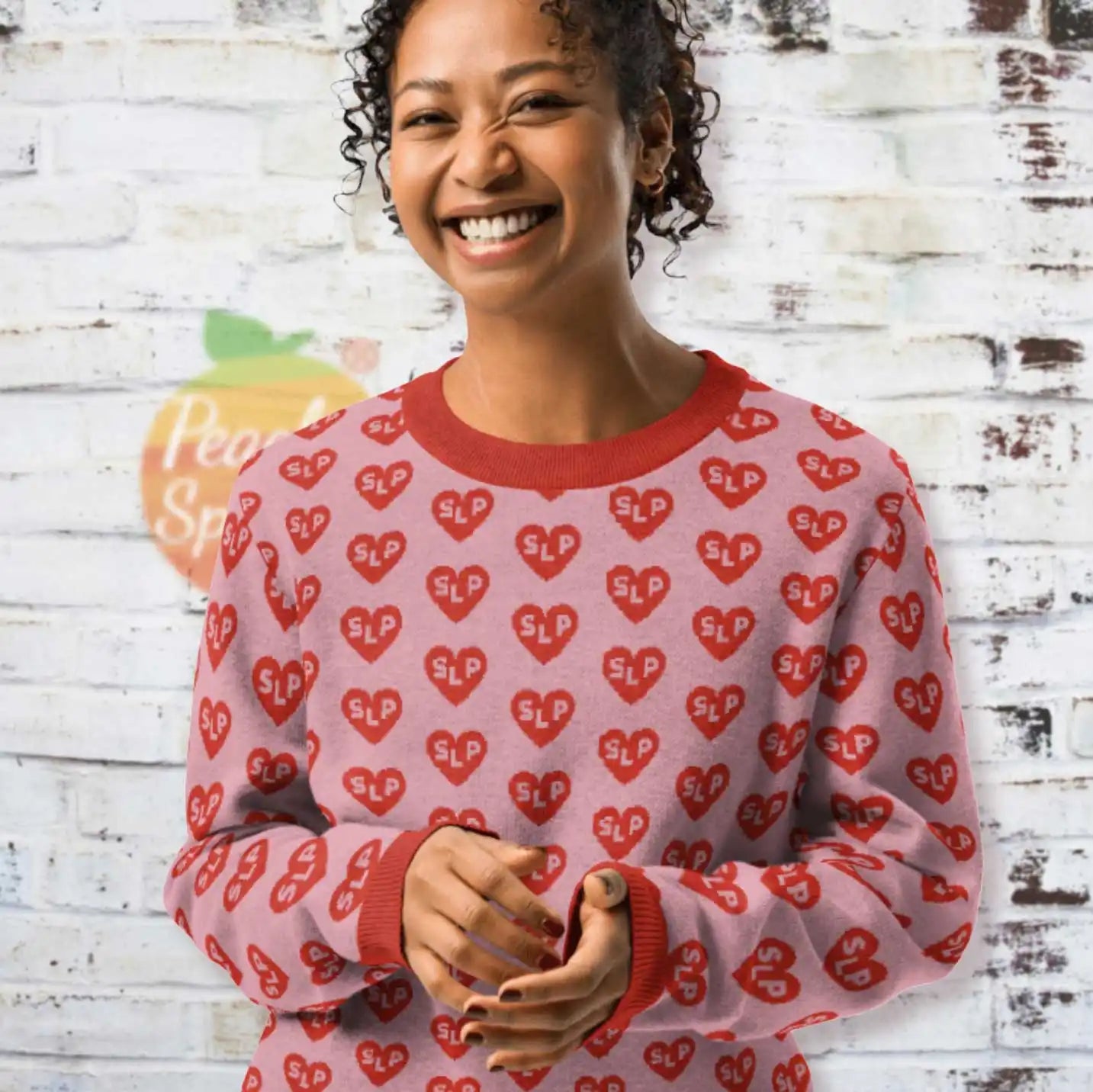 A pink sweater with red heart pattern print.