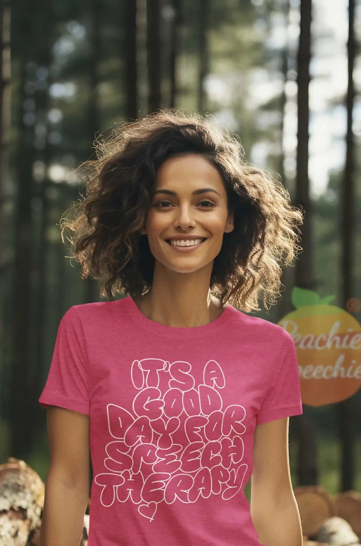 A vibrant pink short-sleeved t-shirt featuring a playful, white outlined text design that reads ’it’s a good day for speech therapy’ with a small heart at the bottom.
